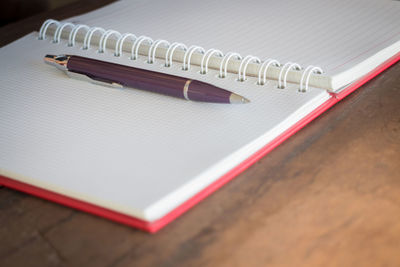 High angle view of pen and diary on table