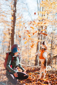 Side view of woman with dog in forest