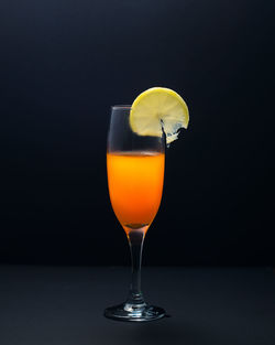 Close-up of wineglass on table against black background