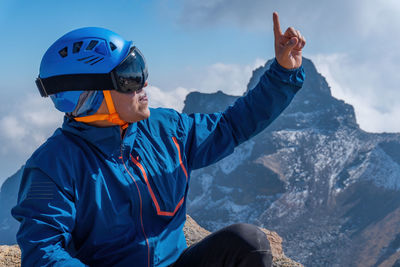 Rear view of man standing on snowcapped mountain