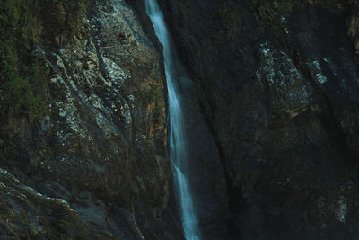 Low angle view of waterfall amidst rocks