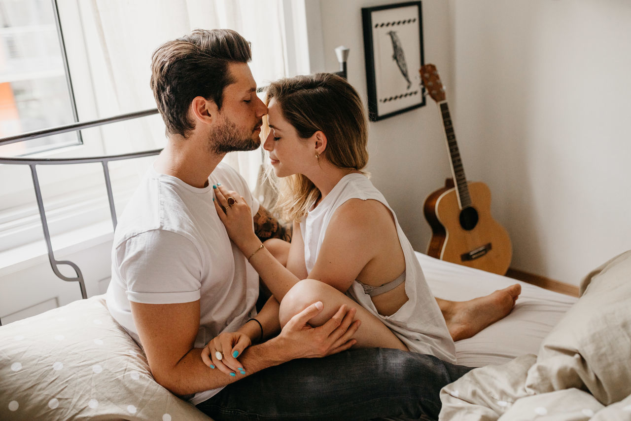 Affectionate couple on bed at home