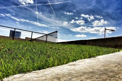 View of grassy field against cloudy sky