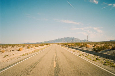 Empty road along countryside landscape