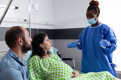 Rear view of female doctor examining patient at clinic