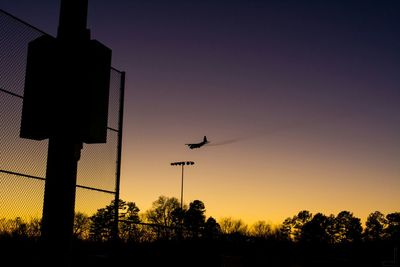 Low angle view of silhouette bird flying against clear sky