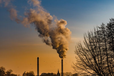 Smoke emitting from chimney against sky at sunset