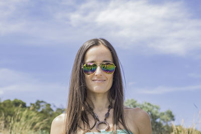 Portrait of smiling young woman against sky