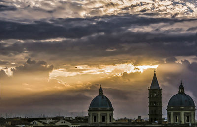 Cathedral against dramatic sky during sunset