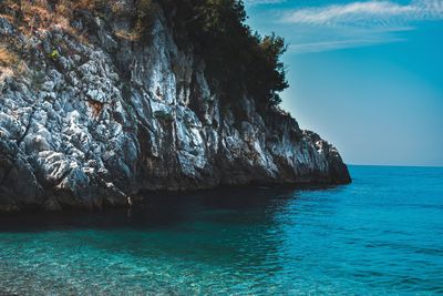 Scenic view of rocks in sea against sky