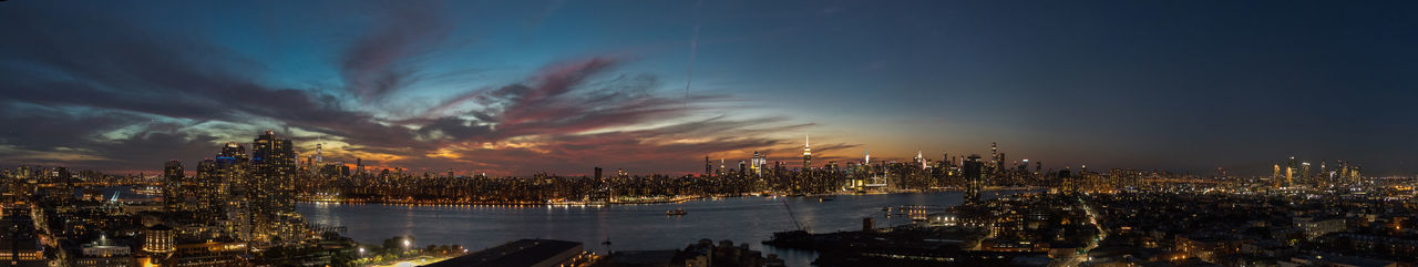 Panoramic view of illuminated buildings against sky at night
