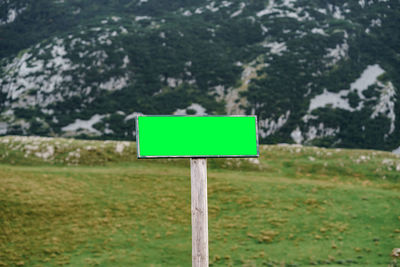 Close-up of road sign on landscape