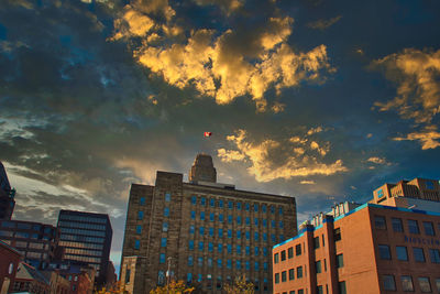 Low angle view of buildings against cloudy sky