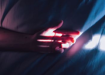 Sunlight falling on hand on bed