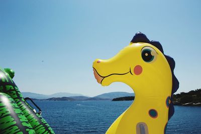 Close-up of yellow boat on sea against clear sky