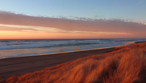Scenic view of beach against sky during sunset