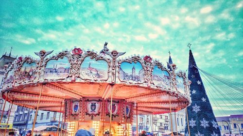 Carousel in amusement park against sky