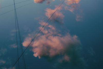 Low angle view of power lines against sky at sunset