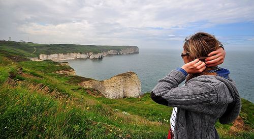 Woman standing on mobile phone against sky