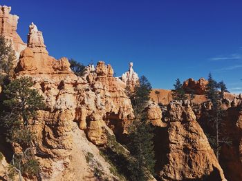 Low angle view of rock formation against clear blue sky