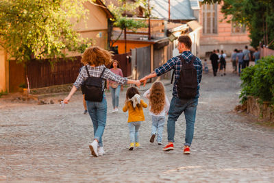 Rear view of people walking on footpath