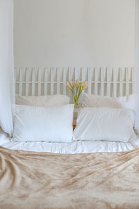 Pillows on bed against wall at home