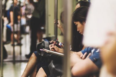 Close-up of woman sitting on bench