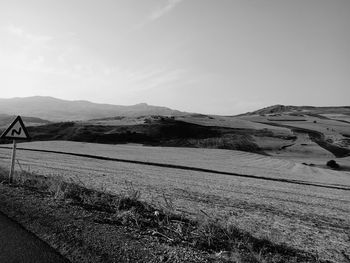 Scenic view of field by mountains against sky