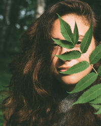 Portrait of woman looking through leaves