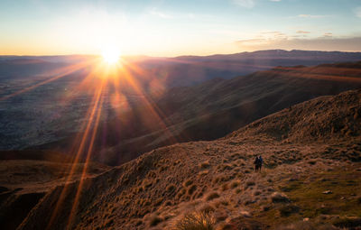 Couple watching sunrise on mountain summit, shot made on roys peak summit in wanaka, new zealand