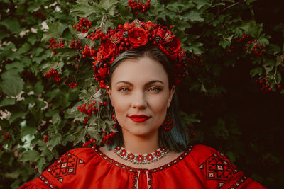 Portrait of young woman standing against plants