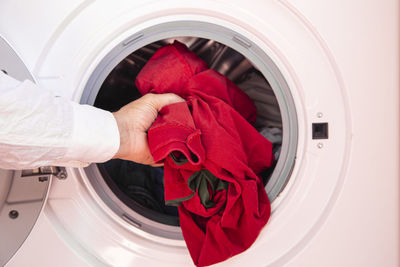 Close up of men loading dirty clothes into washing machine