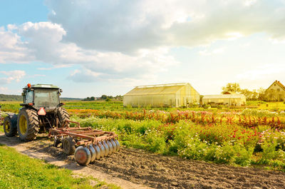 Tractor on agricultural field against sky