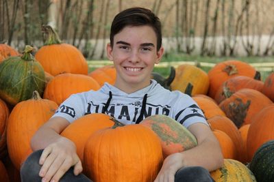 Portrait of smiling man with pumpkins in background