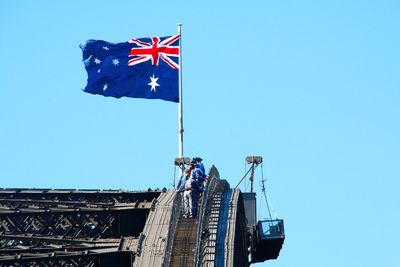 Low angle view of american flag against clear blue sky