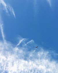 Low angle view of airplane flying against blue sky