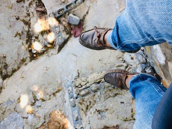 Low section of man standing on rock
