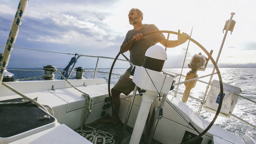 Man steering yacht in sea