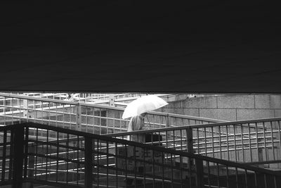 Bird perching on cable against sky