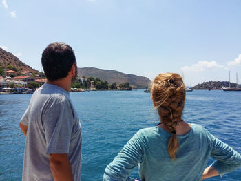 Rear view of people looking at sea against sky