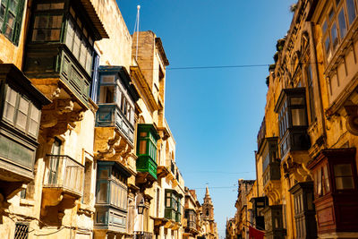 Low angle view of buildings against blue sky