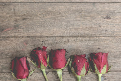 Directly above shot of wet red roses arranged on wooden table