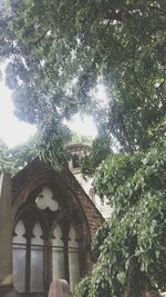 Low angle view of cross against trees