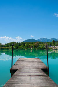 Pier over lake against blue sky