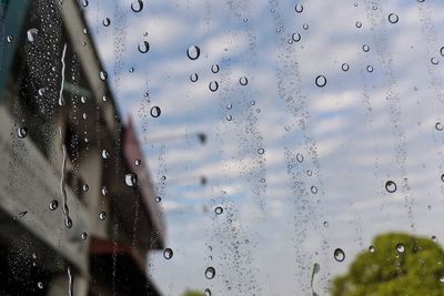 Close-up of waterdrops on glass against window during rainy season