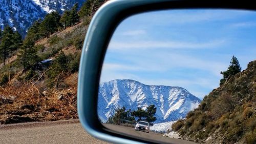 Car on road by mountains against sky