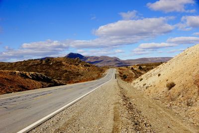 Empty road with mountains in background