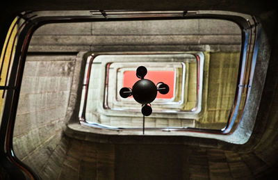 Directly below shot of lighting equipment hanging amidst spiral staircase