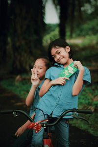 Happy girls on bicycle on road