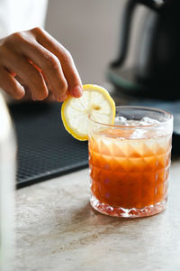 Close-up of hand holding drink on table